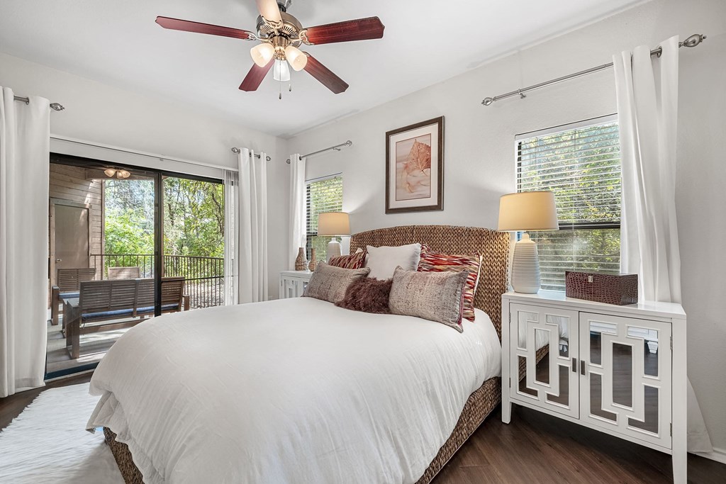 a bedroom with a large bed and a ceiling fan