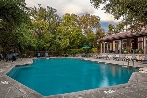 a swimming pool with chairs and a house with a pool