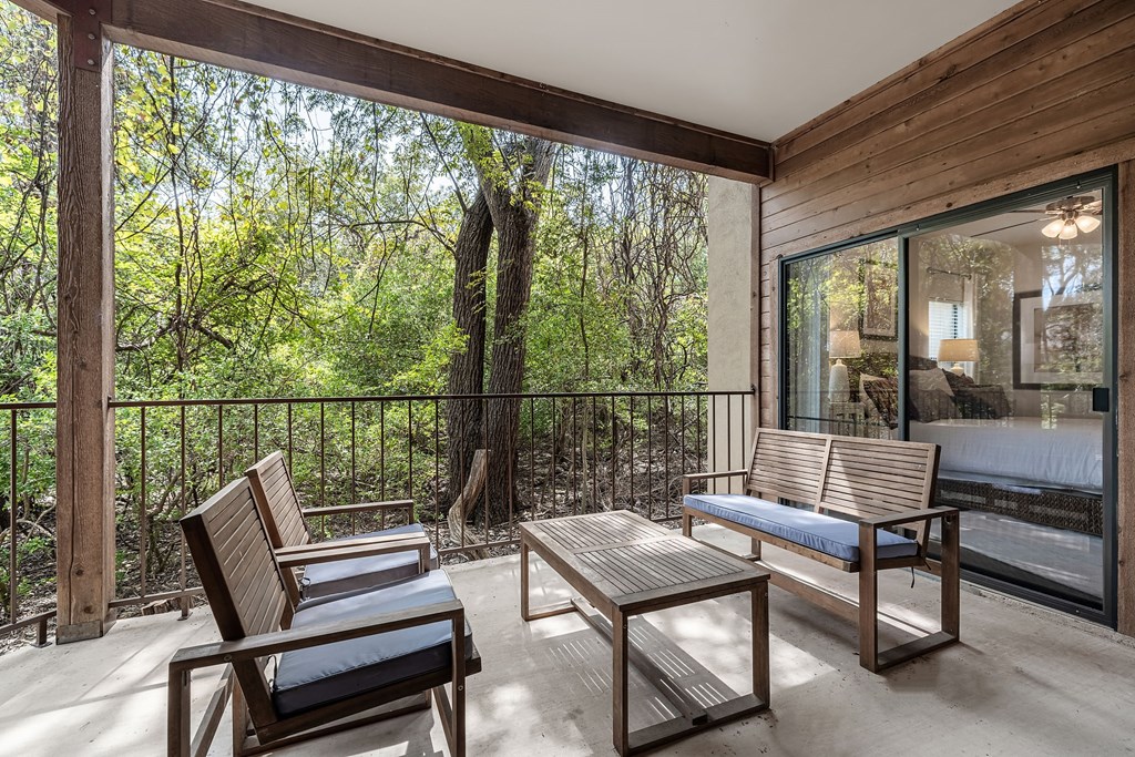 a balcony with two chairs and a table