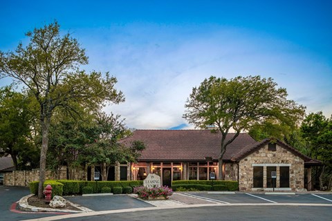 the front of the inn at dusk with trees and a parking lot