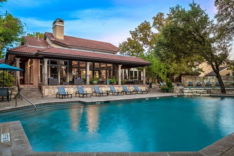 a swimming pool in front of a house with a pool