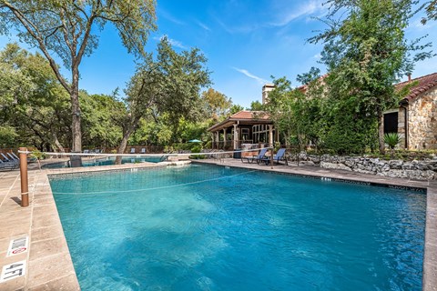 a large swimming pool with a house in the background
