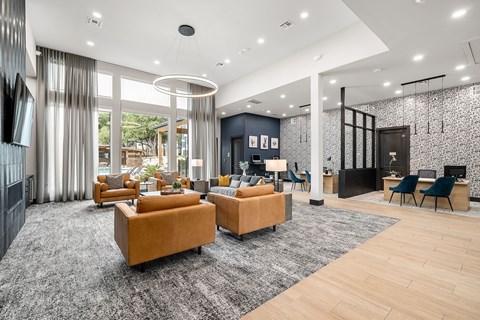 A modern living room with a grey carpet and wooden flooring.