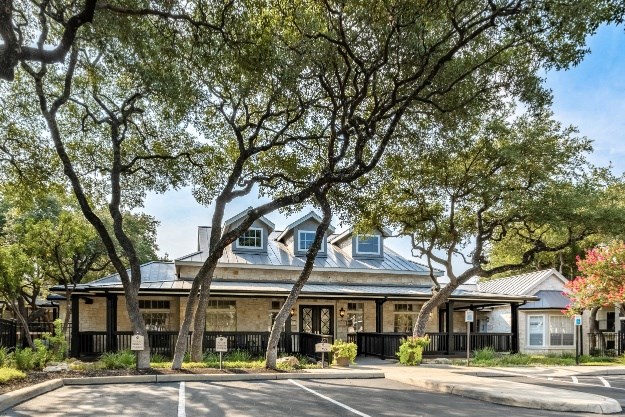 a building with a metal roof and a parking lot in front of it