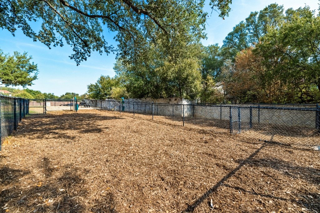 a large fenced in area with trees in the background