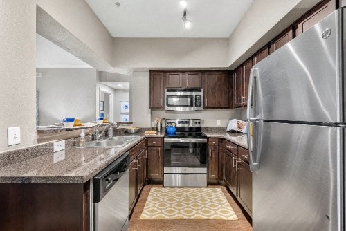 a kitchen with wooden cabinets and stainless steel appliances
