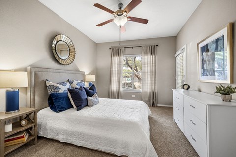 a bedroom with a large bed and a ceiling fan