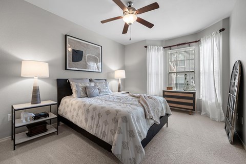 A bedroom with a large bed and a ceiling fan.