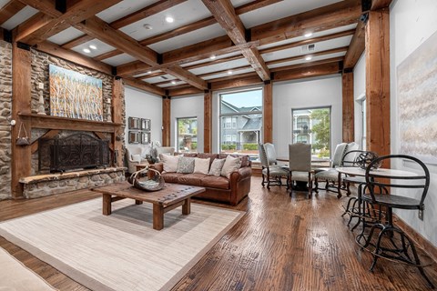 A living room with a stone fireplace and wooden floors.
