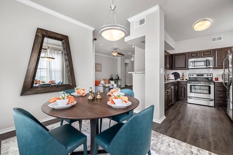 A modern kitchen with a dining table set for two.