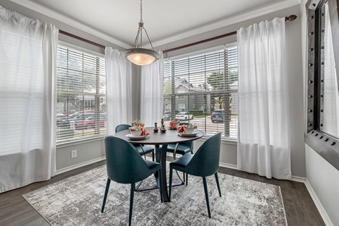 A dining room with a table set for four.