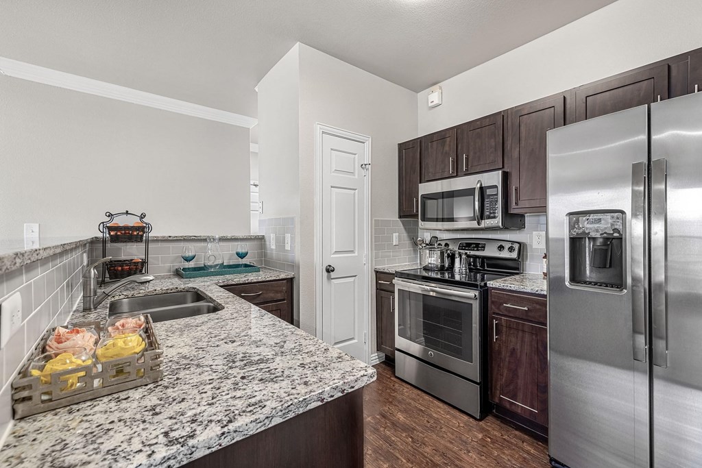 a kitchen with stainless steel appliances and granite counter tops