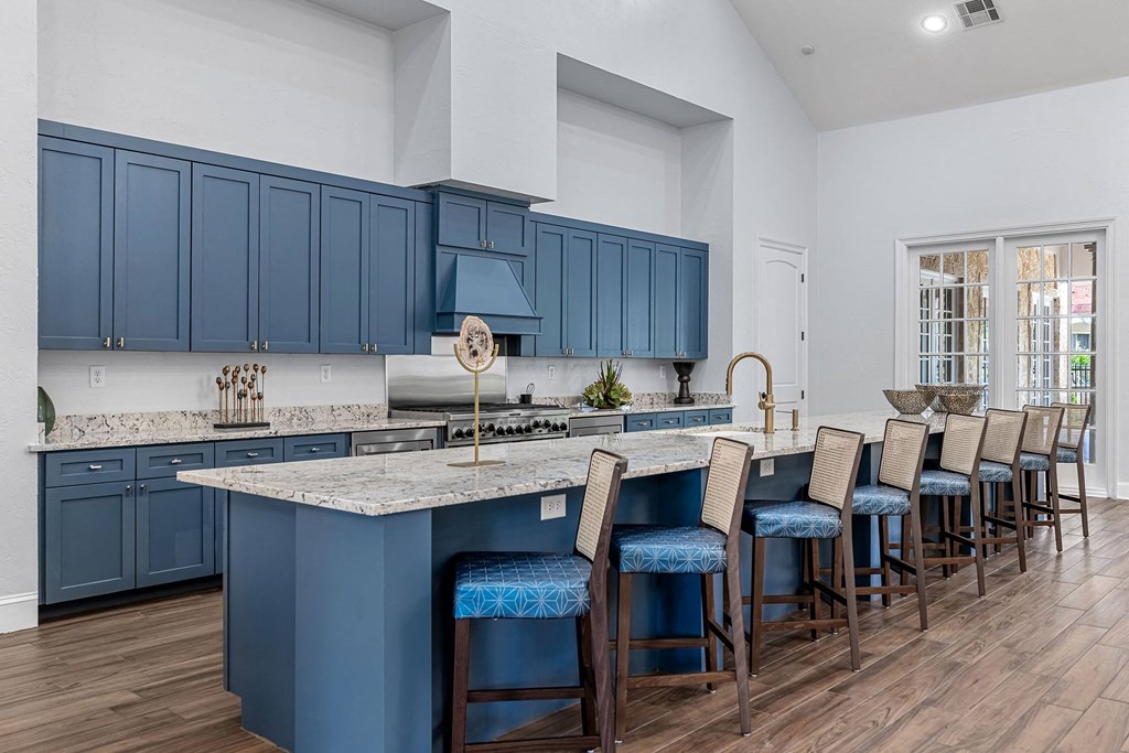 a kitchen with blue cabinets and a large island with bar stools