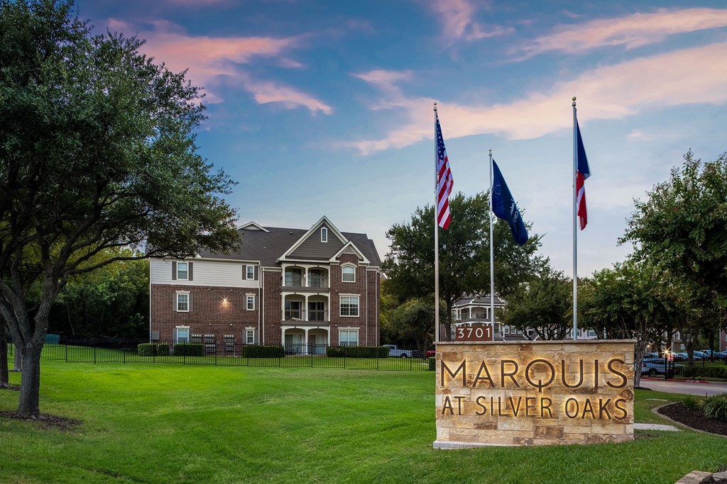 a sign for the marcus at silver oaks in front of an apartment building