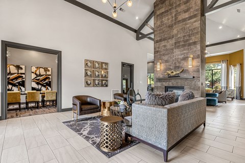 A living room with a grey couch and a fireplace.