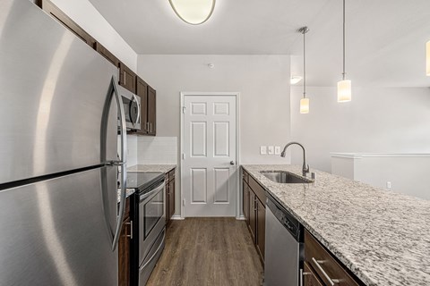 A kitchen with a stainless steel refrigerator and a white door.