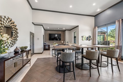 A modern dining room with a dark wood floor and a large mirror on the wall.