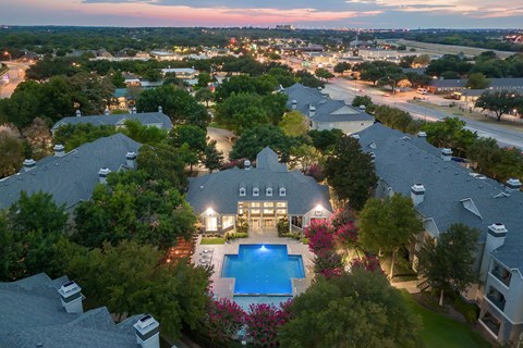 A large house with a pool in the middle of a garden.