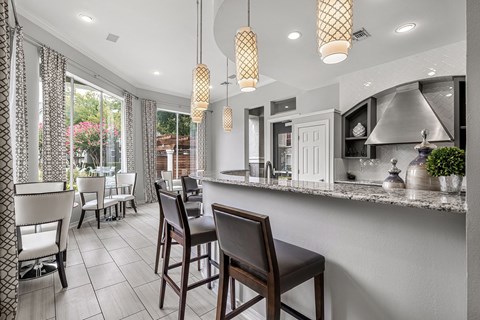 A kitchen with a bar area and chairs.