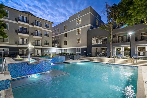 A large swimming pool in front of apartment buildings.