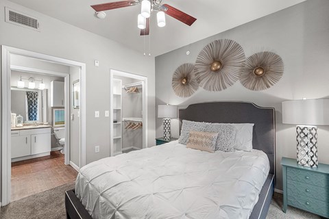 A bedroom with a large bed and a ceiling fan.