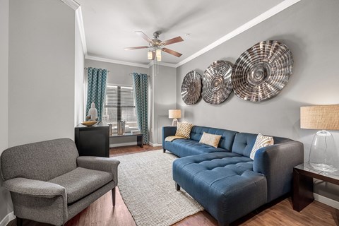 A living room with a grey couch and a grey armchair.