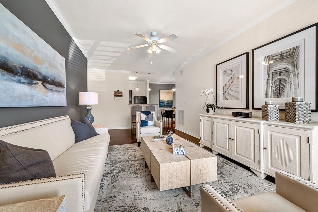 a living room filled with furniture and a ceiling fan