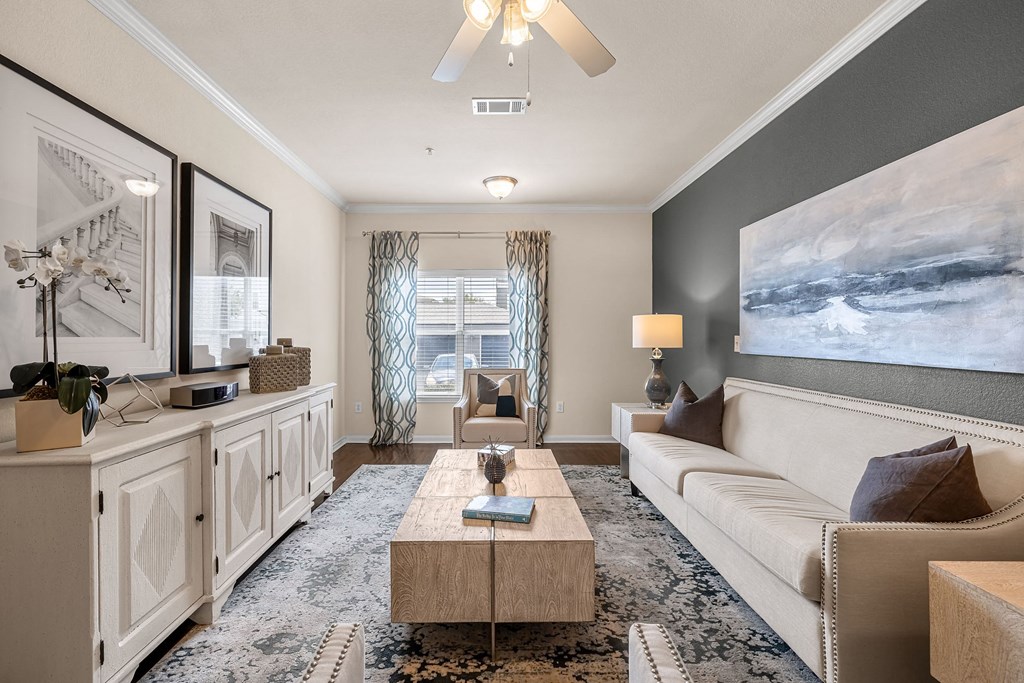 a living room filled with furniture and a ceiling fan