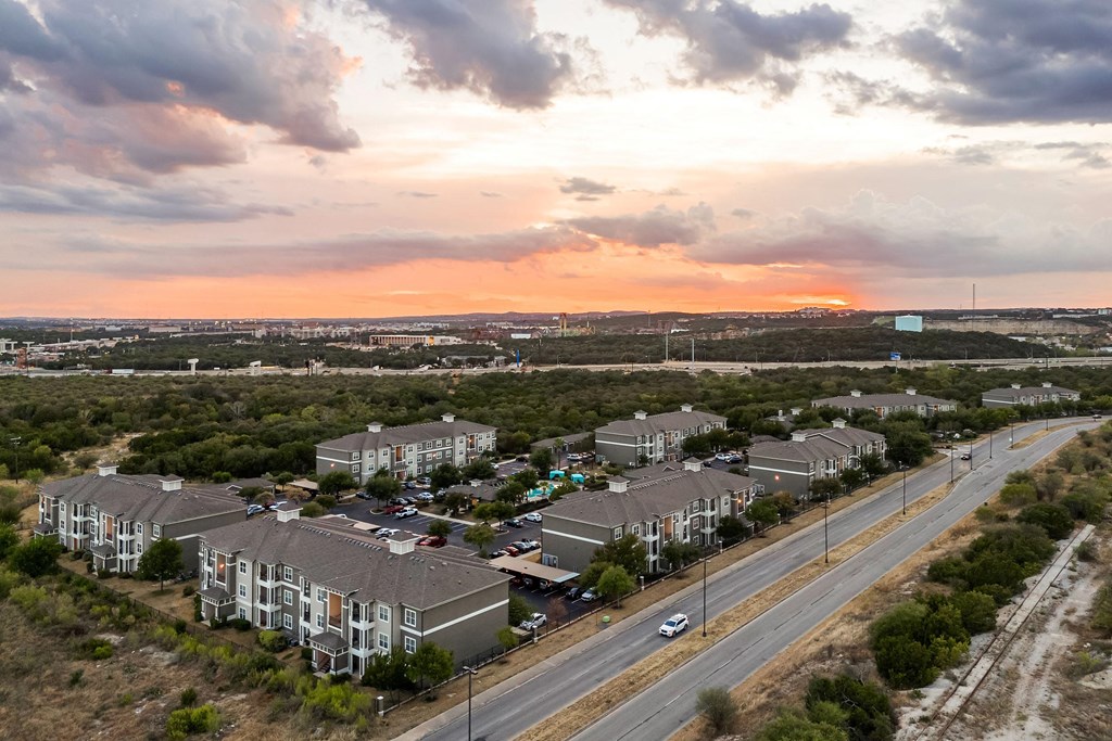 an aerial view of a row of houses with a sunset in the background