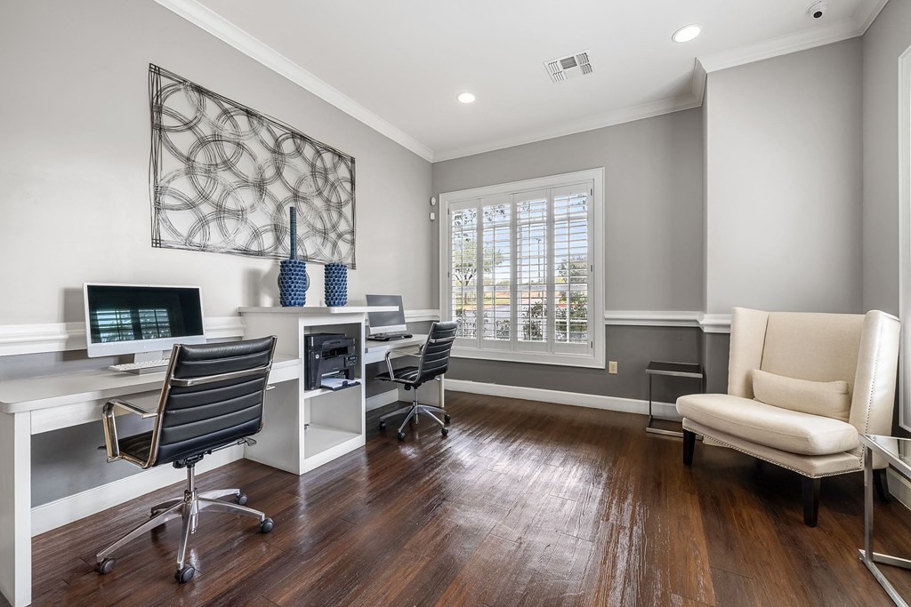 a home office with two computer desks and a chair