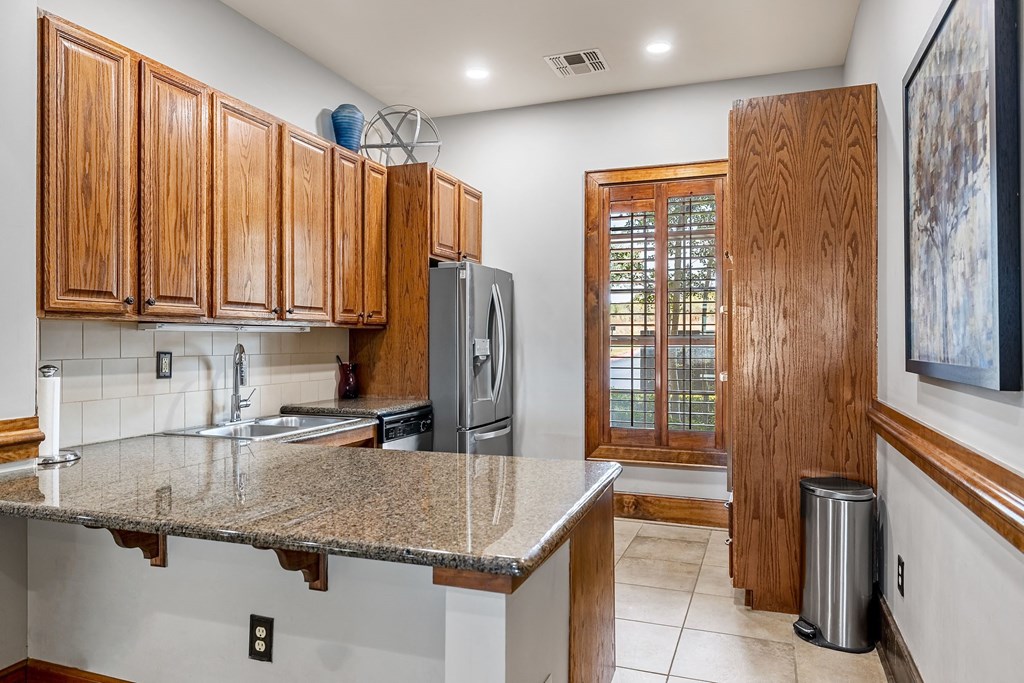 a kitchen with wooden cabinets and a granite counter top
