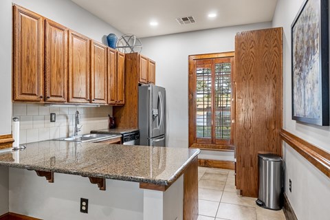 the kitchen is equipped with stainless steel appliances and granite counter tops