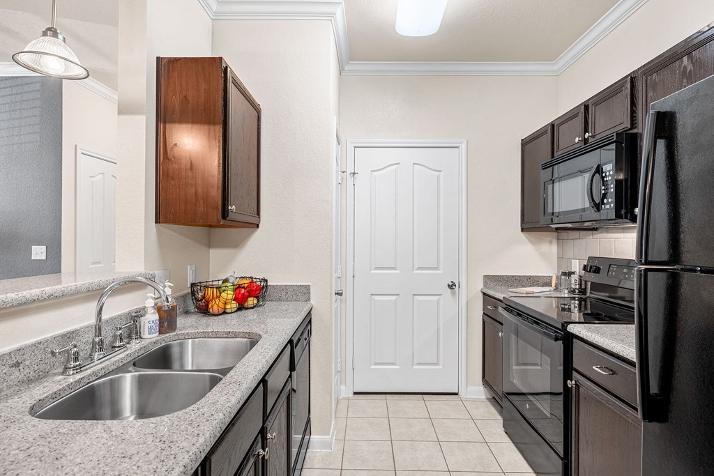 a kitchen with black appliances and white countertops