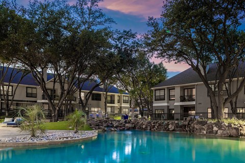 A beautiful view of a resort with a pool and trees.