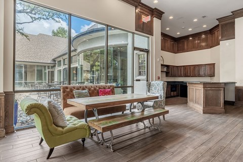 A modern kitchen with a green chair and a wooden table.