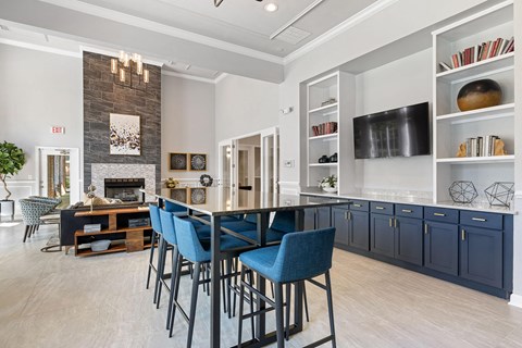 A modern kitchen with blue chairs and a fireplace.