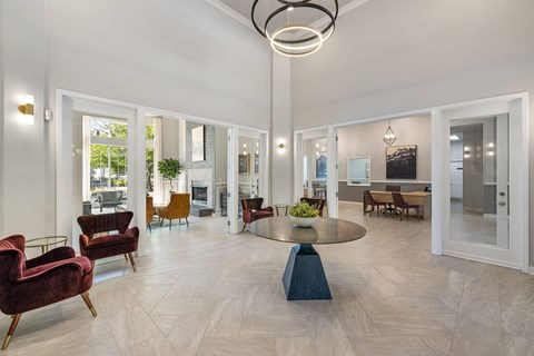A spacious living room with a round table and chairs.
