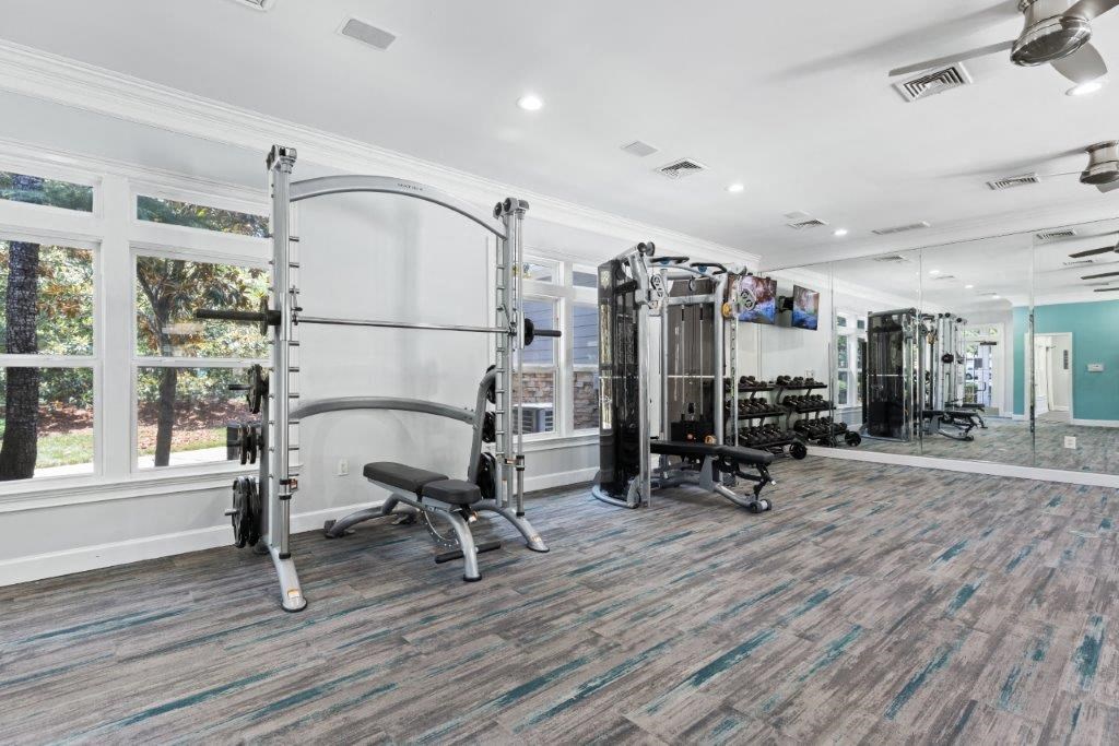 a gym with a large window and a wall of gym equipment
