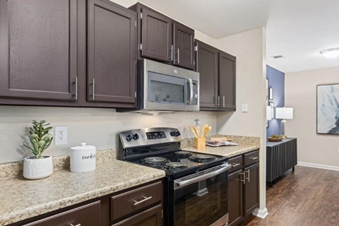 A kitchen with brown cabinets and a granite countertop.