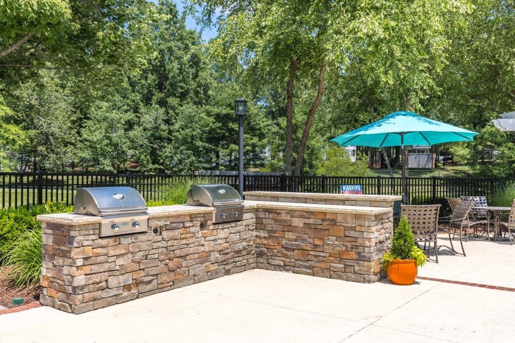 a patio with a grill and a brick wall