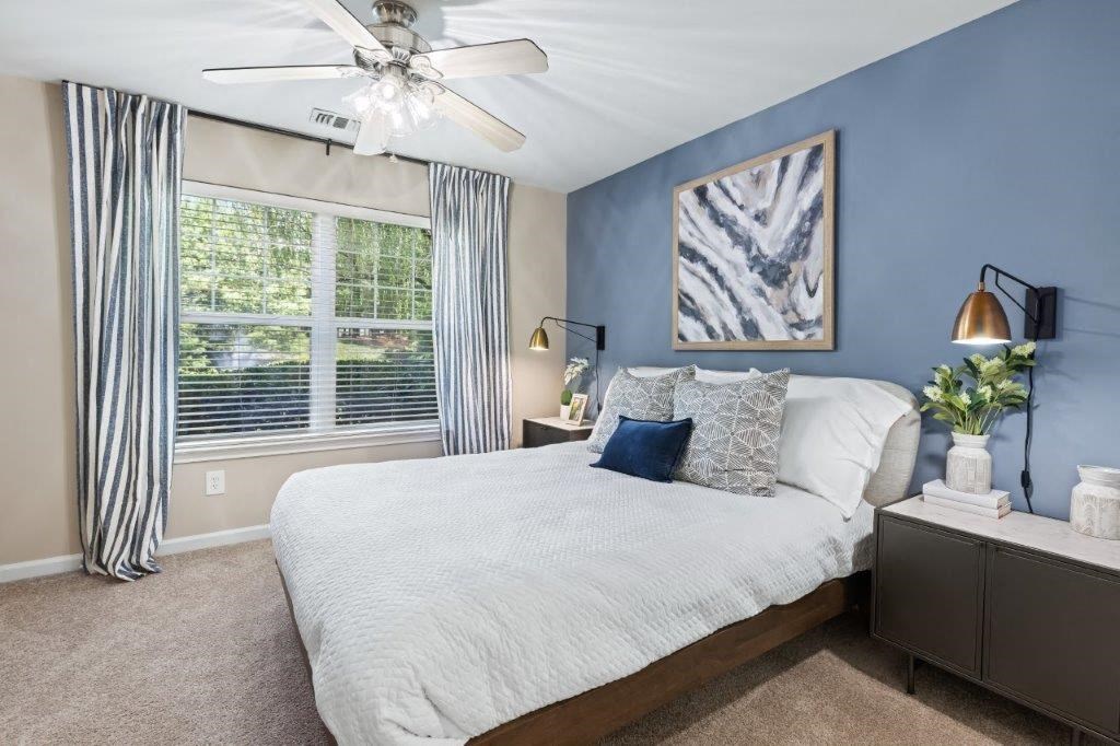 a bedroom with a large bed and a ceiling fan