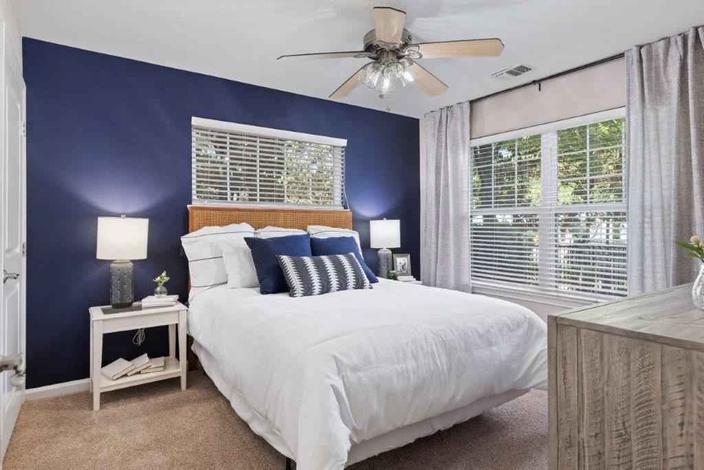 a bedroom with a large bed and a ceiling fan
