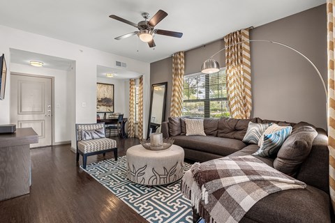 A living room with a brown couch and a patterned rug.
