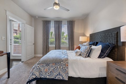A bedroom with a large bed and a ceiling fan.