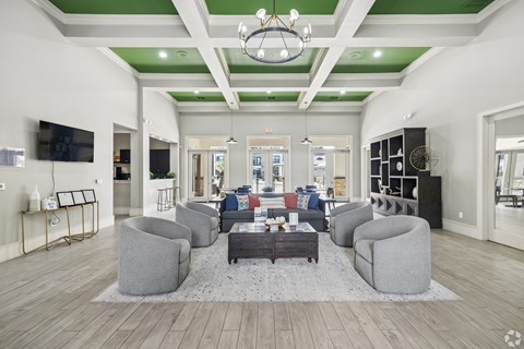 A spacious living room with a grey sofa set and a coffee table in the center.