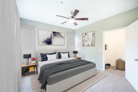 A bedroom with a large bed and a ceiling fan.