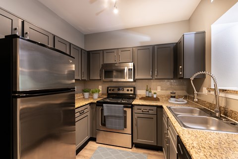 A modern kitchen with a stainless steel refrigerator and oven.
