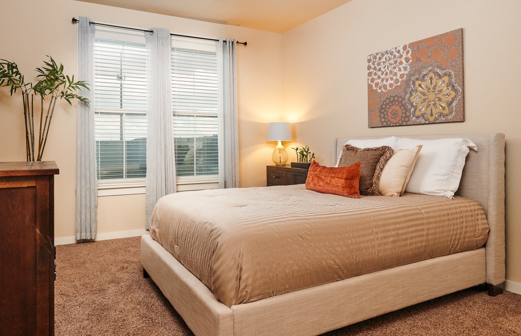 A bedroom with a large bed and a painting on the wall.