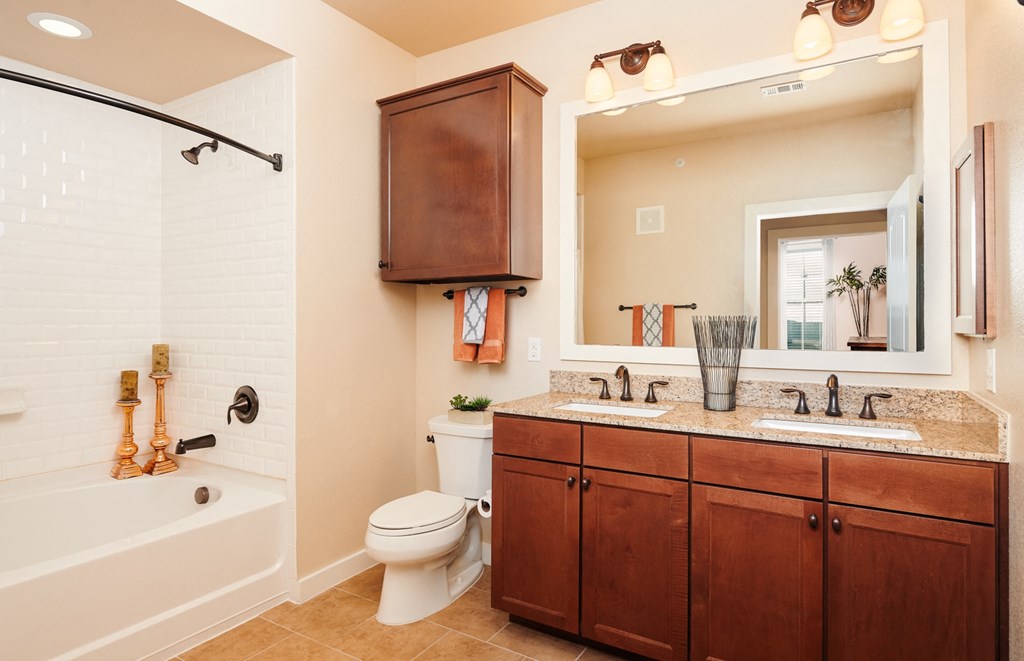 A bathroom with a white tub, toilet, and sink.