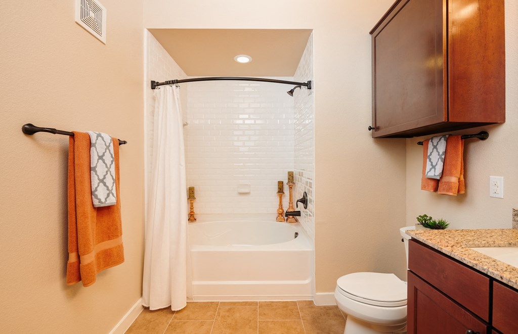 A bathroom with a toilet, sink, and shower.